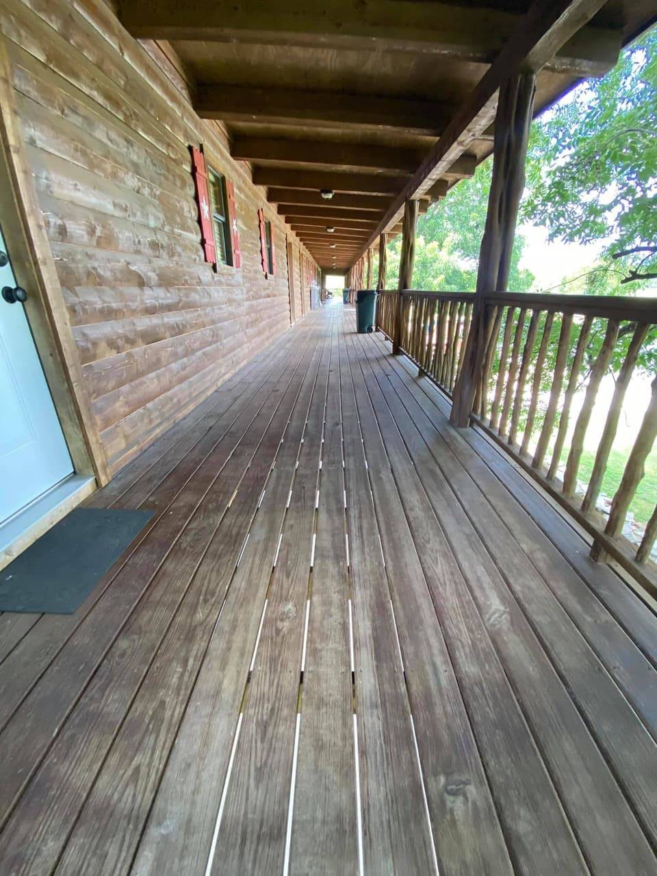 Long exterior porch corridor at Sabinal River Lodge with red window shutters